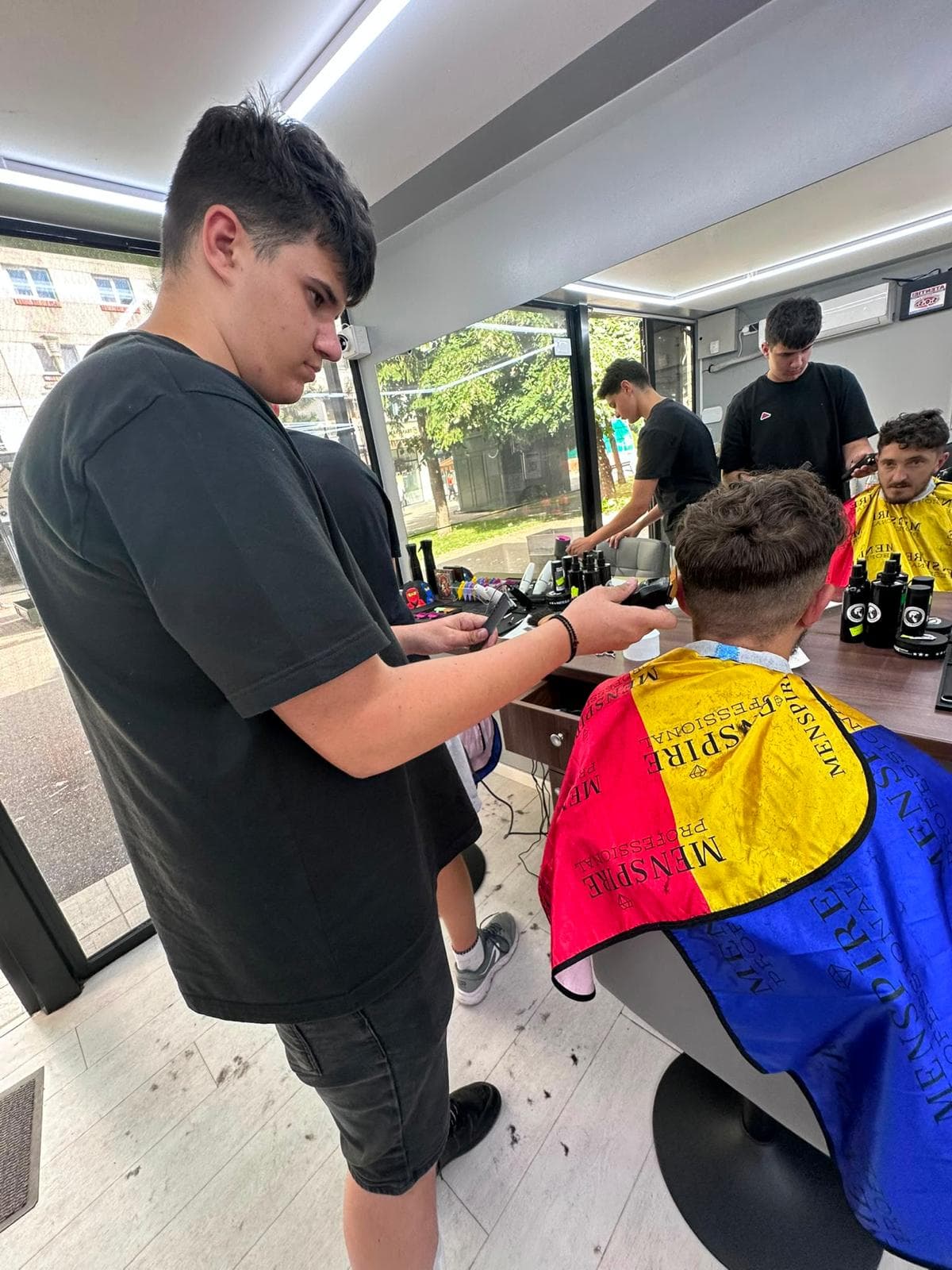 Cursant sub 18 ani la cursul de frizerie PointCut Pitești, la lucru pe model real sub supravegherea instructorului — imaginea 10