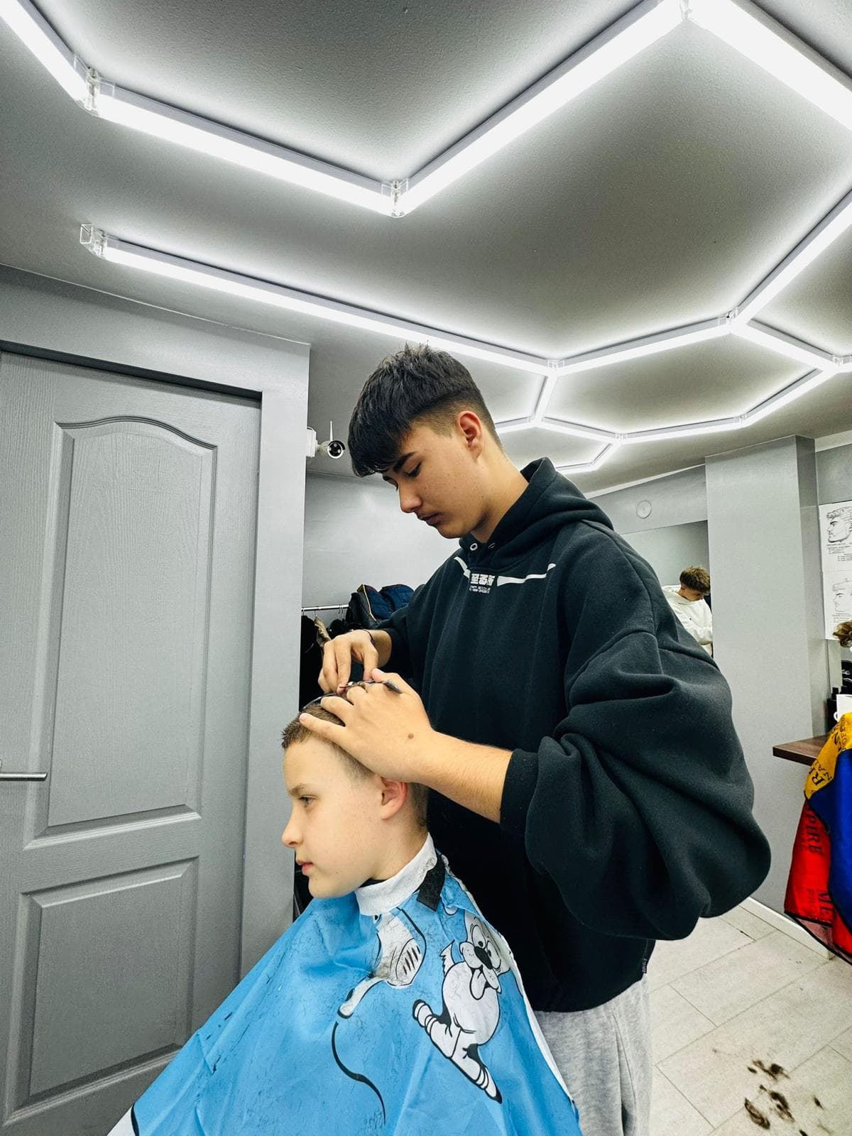 Cursant sub 18 ani la cursul de frizerie PointCut Pitești, la lucru pe model real sub supravegherea instructorului — imaginea 21