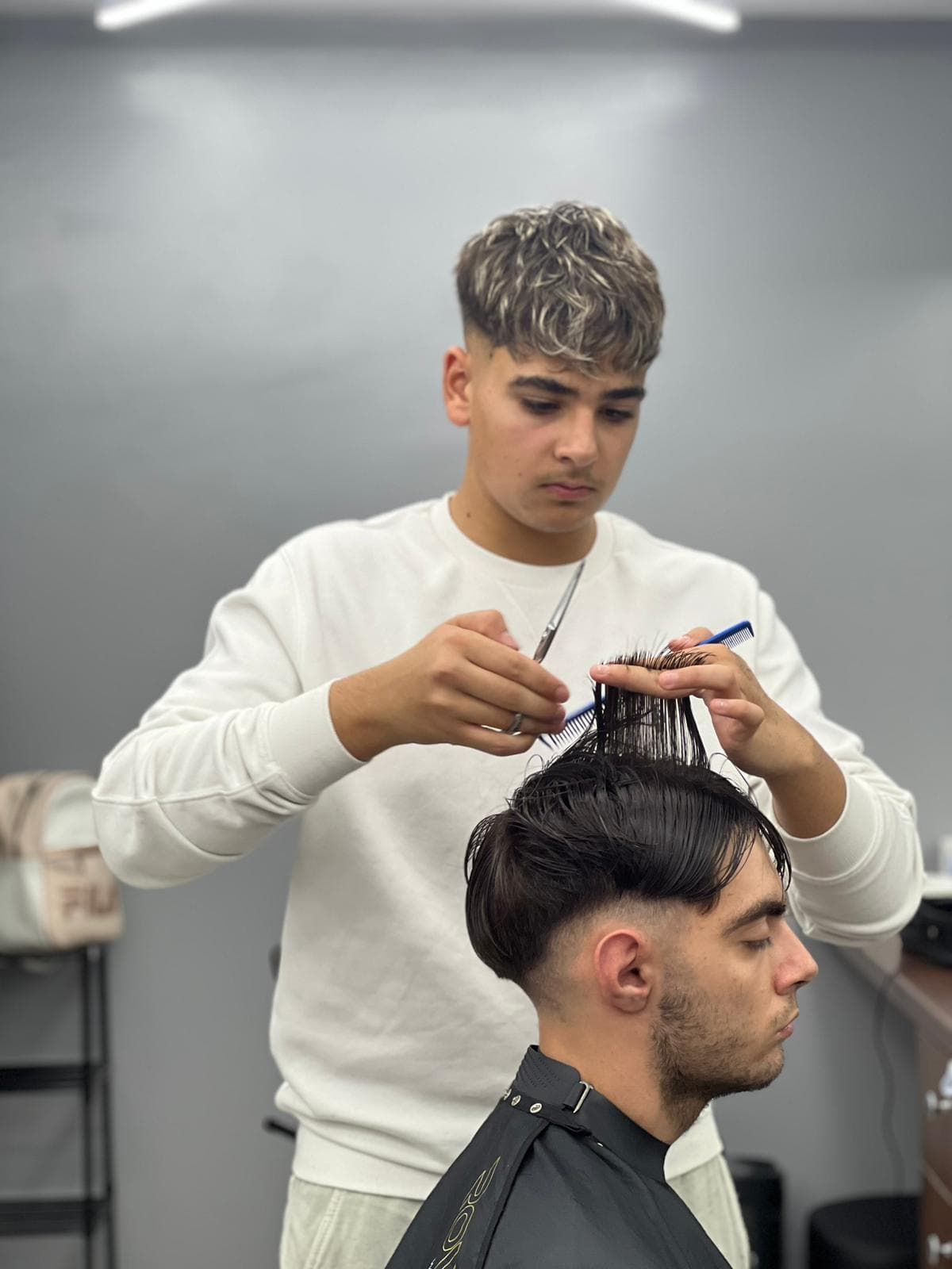 Cursant sub 18 ani la cursul de frizerie PointCut Pitești, la lucru pe model real sub supravegherea instructorului — imaginea 24