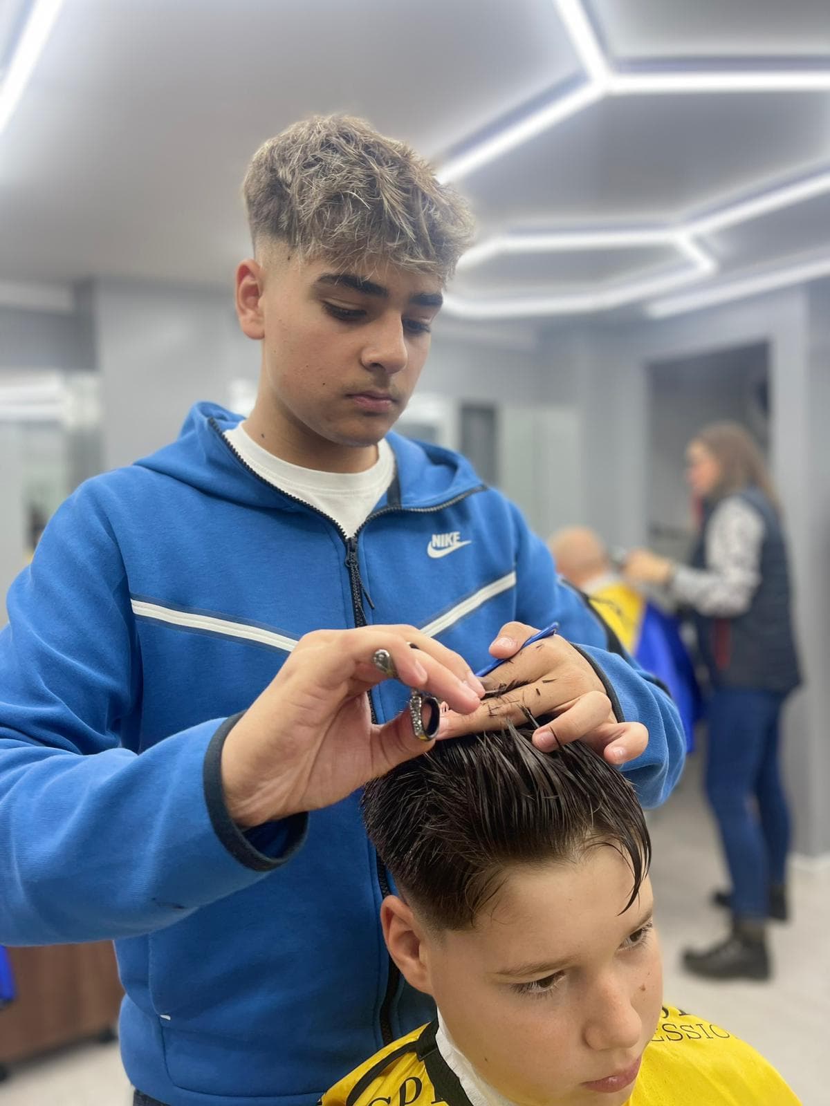 Cursant sub 18 ani la cursul de frizerie PointCut Pitești, la lucru pe model real sub supravegherea instructorului — imaginea 29