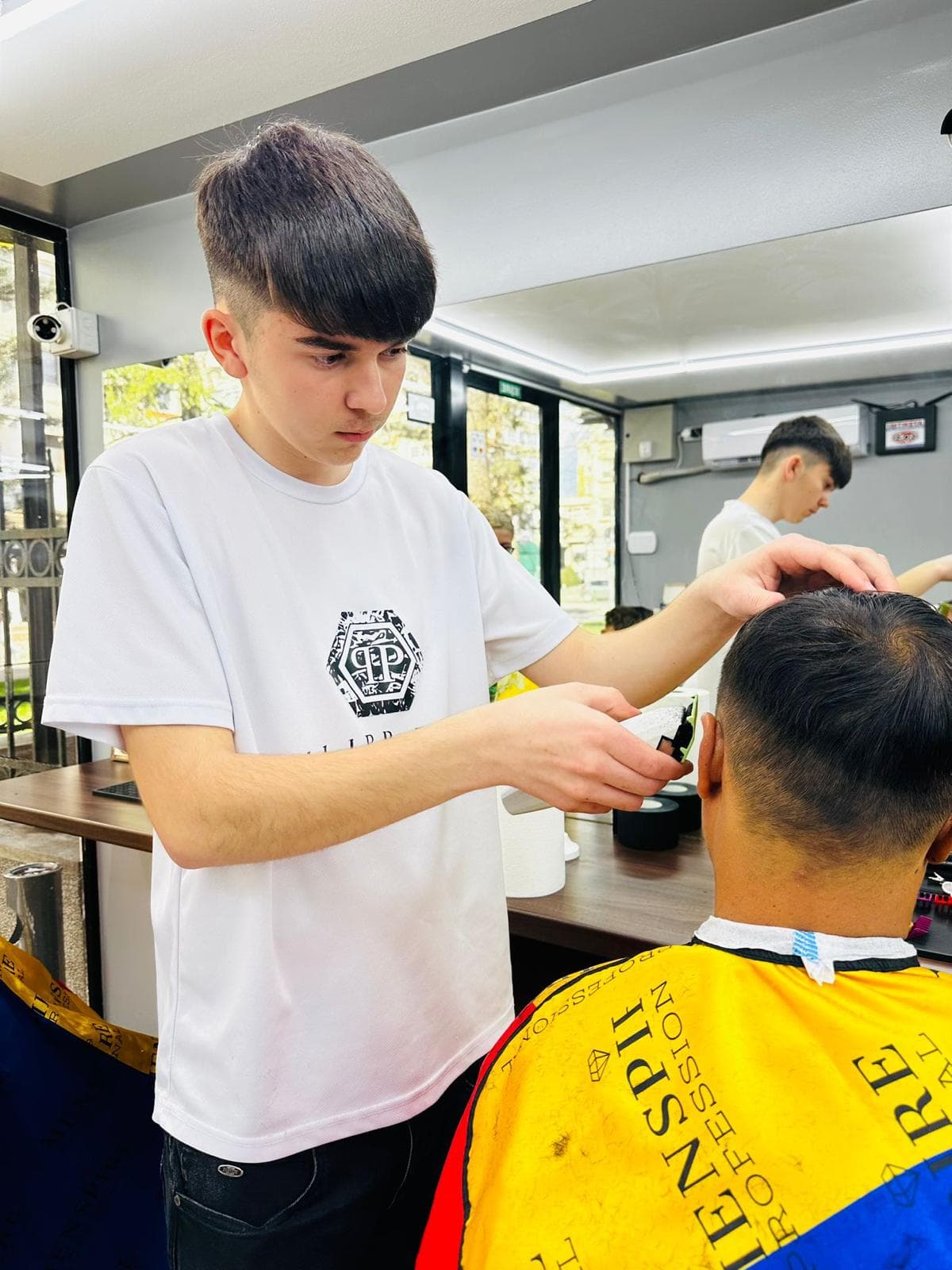 Cursant sub 18 ani la cursul de frizerie PointCut Pitești, la lucru pe model real sub supravegherea instructorului — imaginea 33
