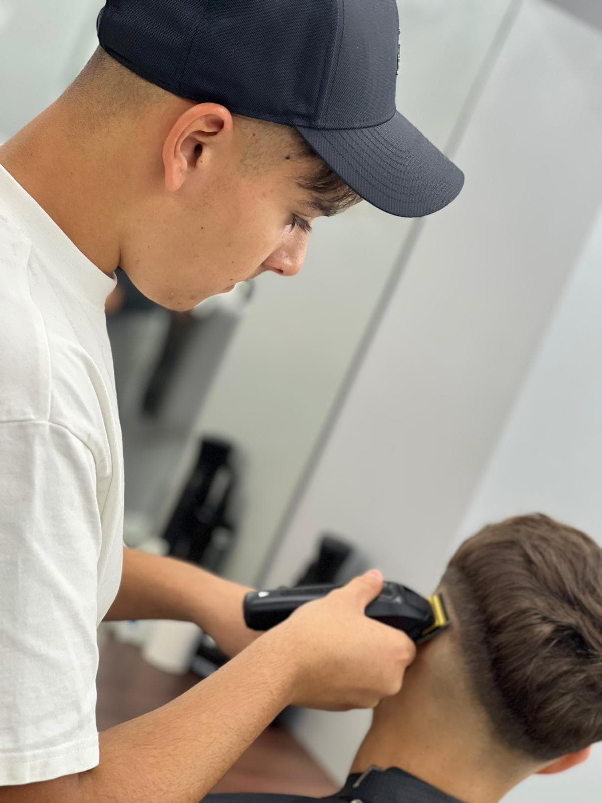 Cursant sub 18 ani la cursul de frizerie PointCut Pitești, la lucru pe model real sub supravegherea instructorului — imaginea 34