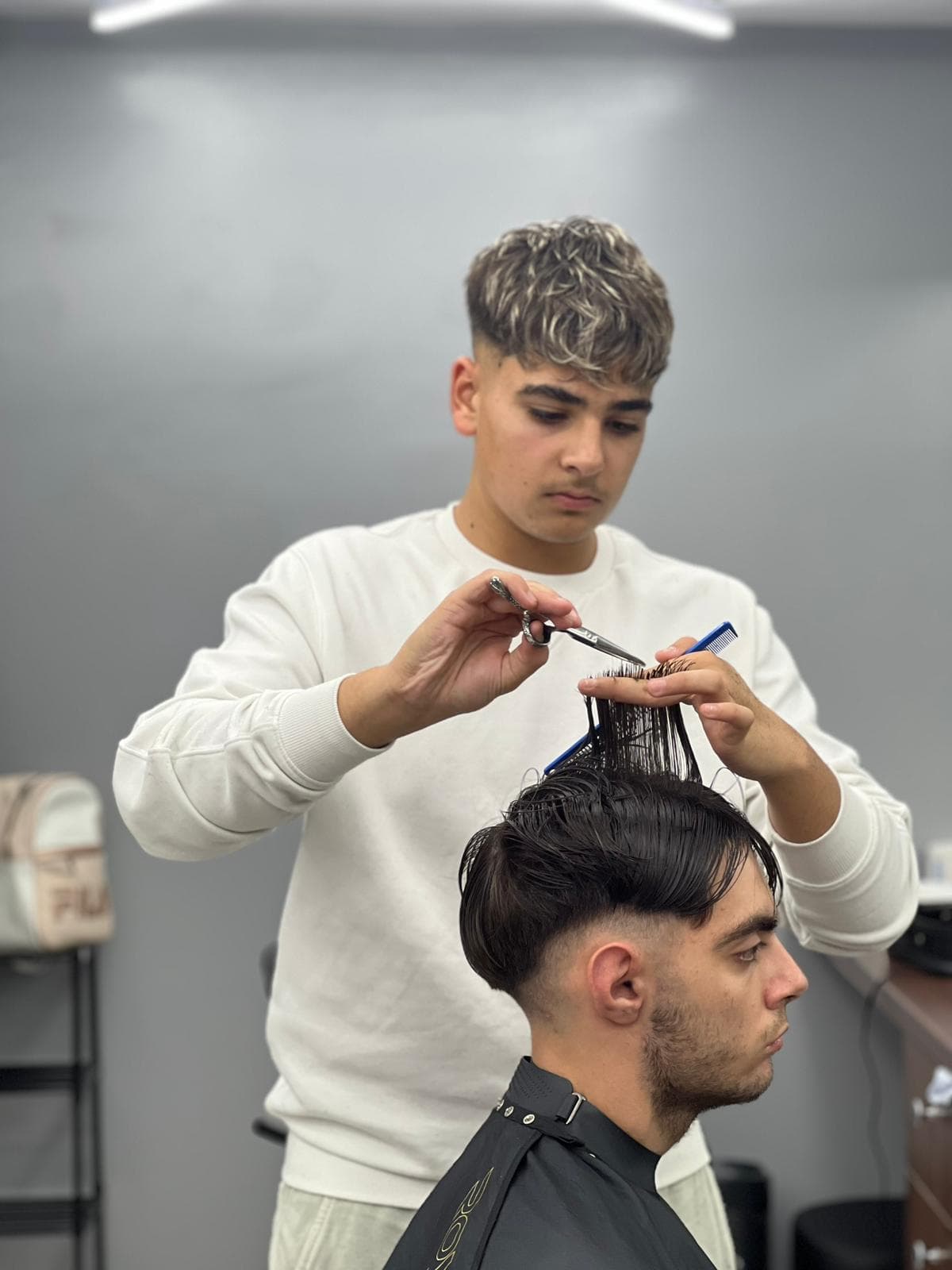 Cursant sub 18 ani la cursul de frizerie PointCut Pitești, la lucru pe model real sub supravegherea instructorului — imaginea 38