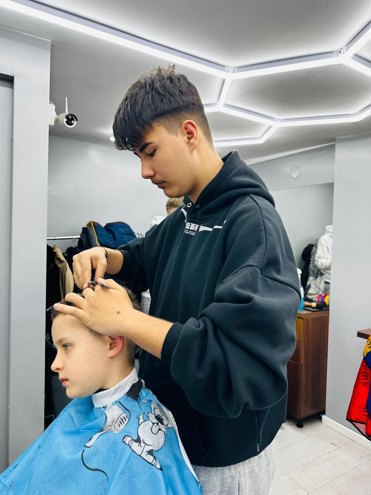Cursant sub 18 ani la cursul de frizerie PointCut Pitești, la lucru pe model real sub supravegherea instructorului — imaginea 39