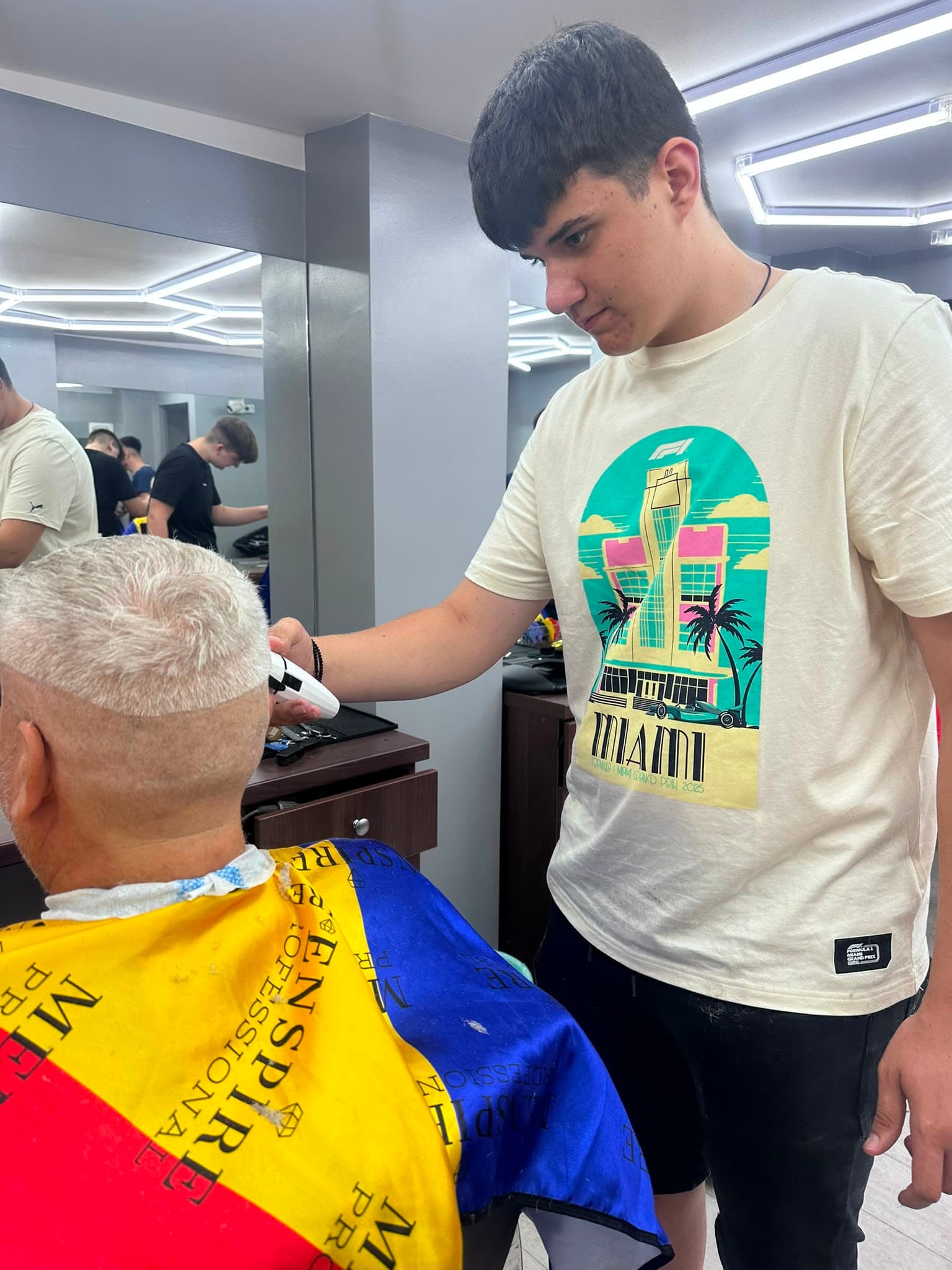 Cursant sub 18 ani la cursul de frizerie PointCut Pitești, la lucru pe model real sub supravegherea instructorului — imaginea 4