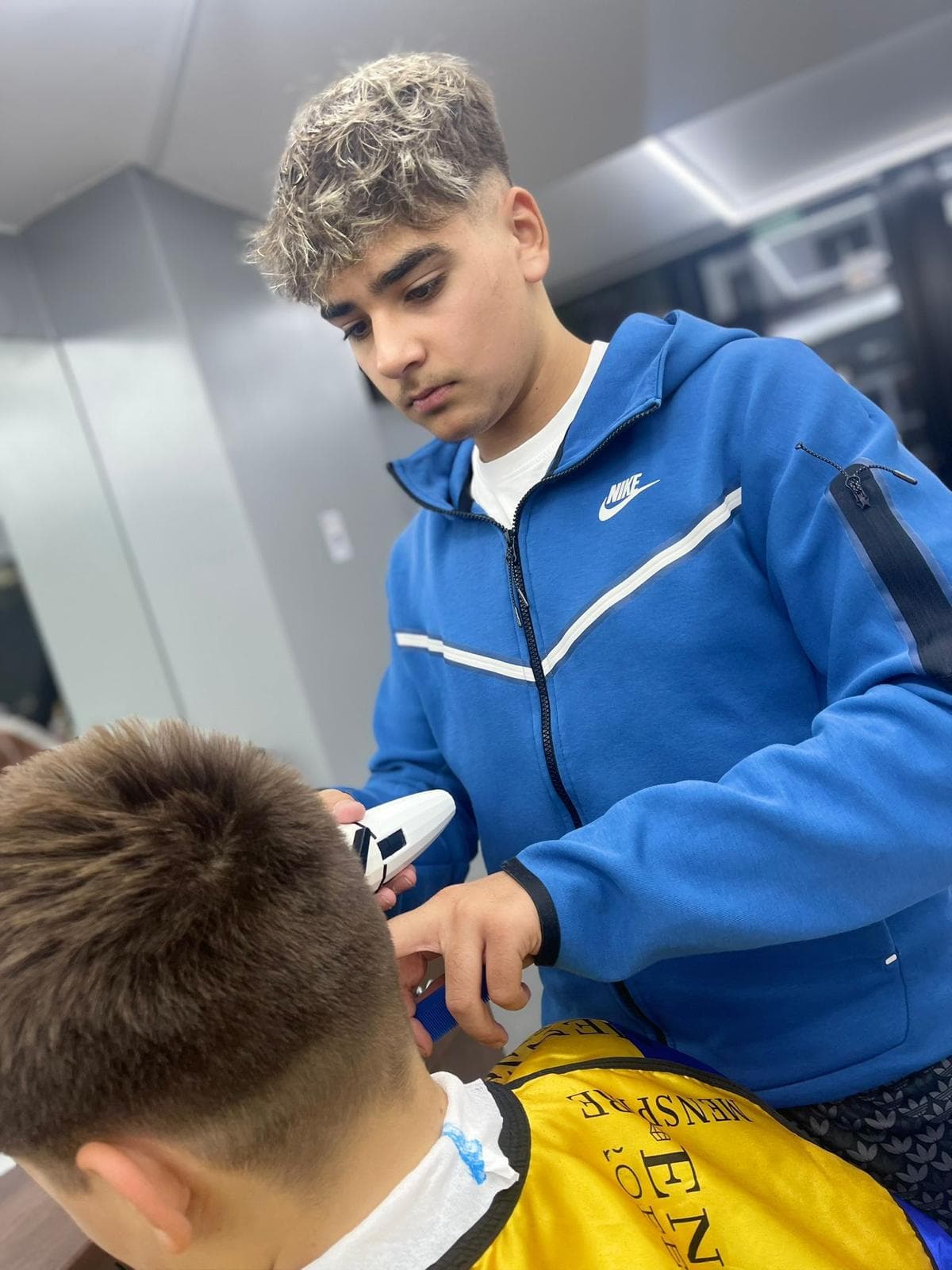 Cursant sub 18 ani la cursul de frizerie PointCut Pitești, la lucru pe model real sub supravegherea instructorului — imaginea 44