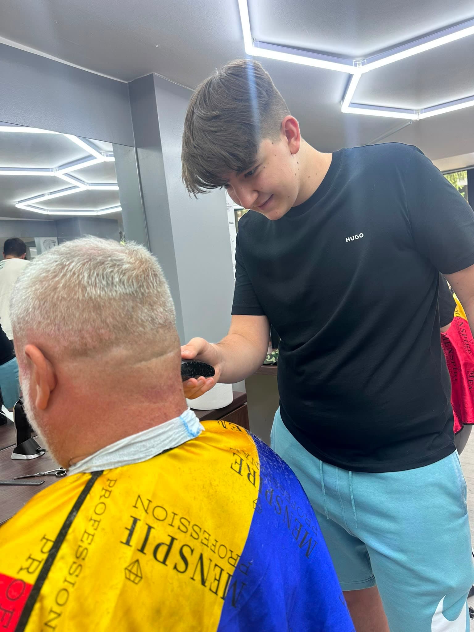 Cursant sub 18 ani la cursul de frizerie PointCut Pitești, la lucru pe model real sub supravegherea instructorului — imaginea 5