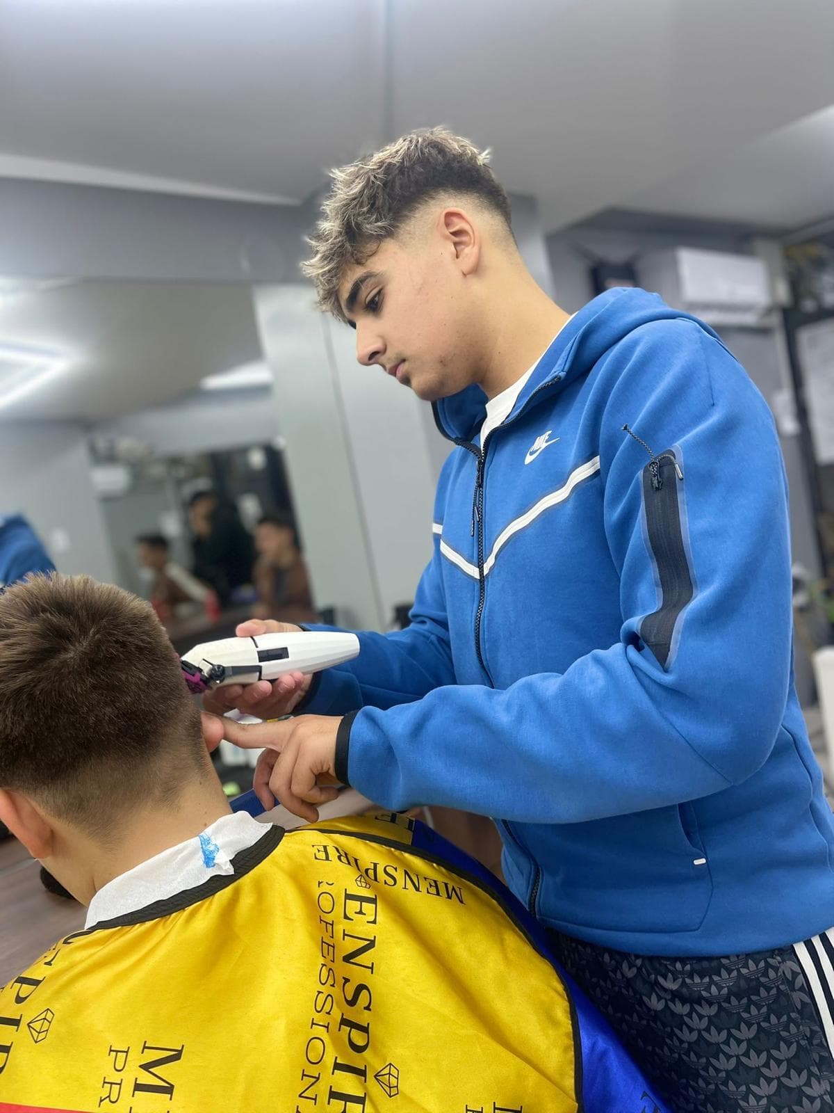 Cursant sub 18 ani la cursul de frizerie PointCut Pitești, la lucru pe model real sub supravegherea instructorului — imaginea 56