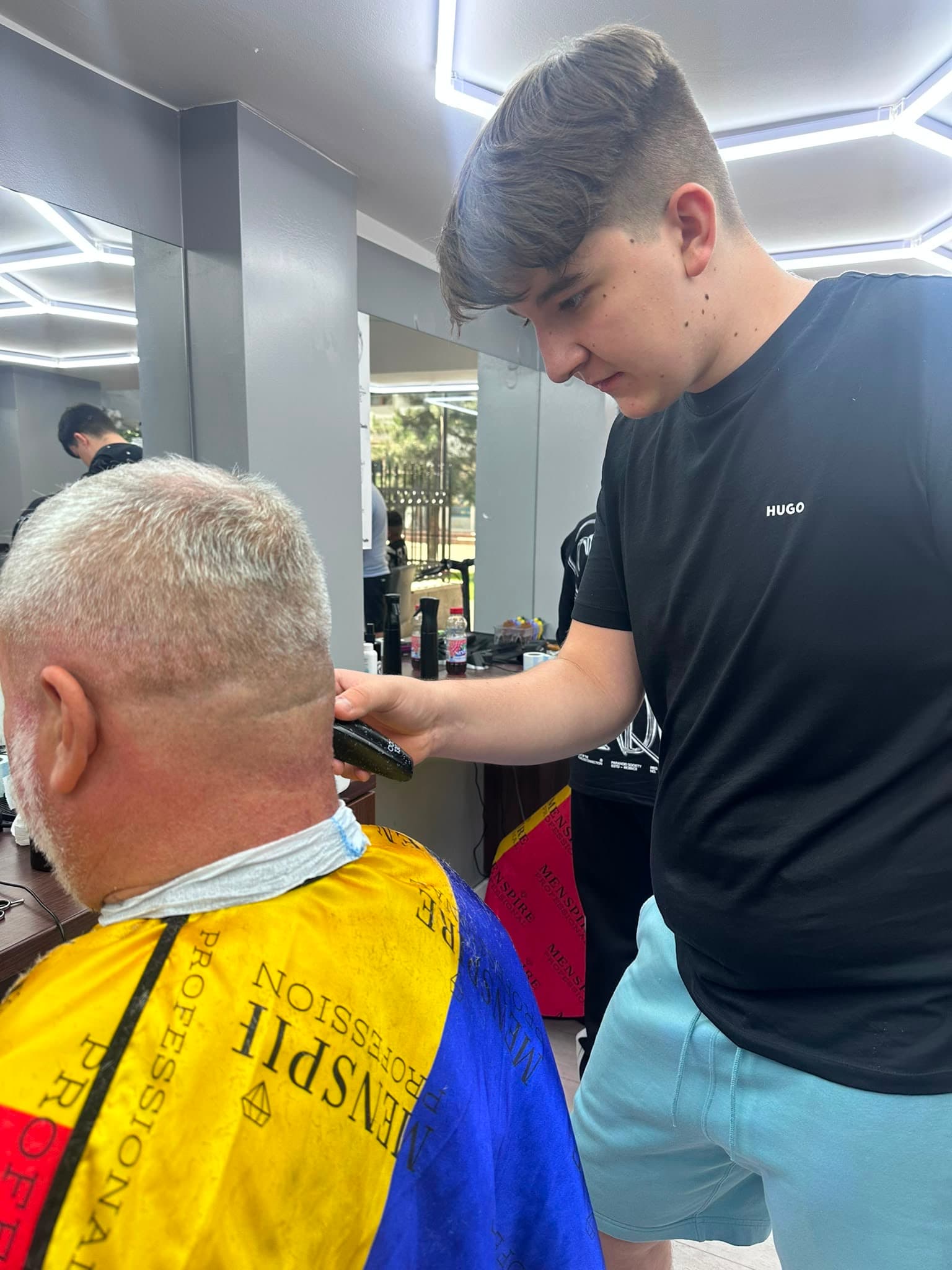 Cursant sub 18 ani la cursul de frizerie PointCut Pitești, la lucru pe model real sub supravegherea instructorului — imaginea 6
