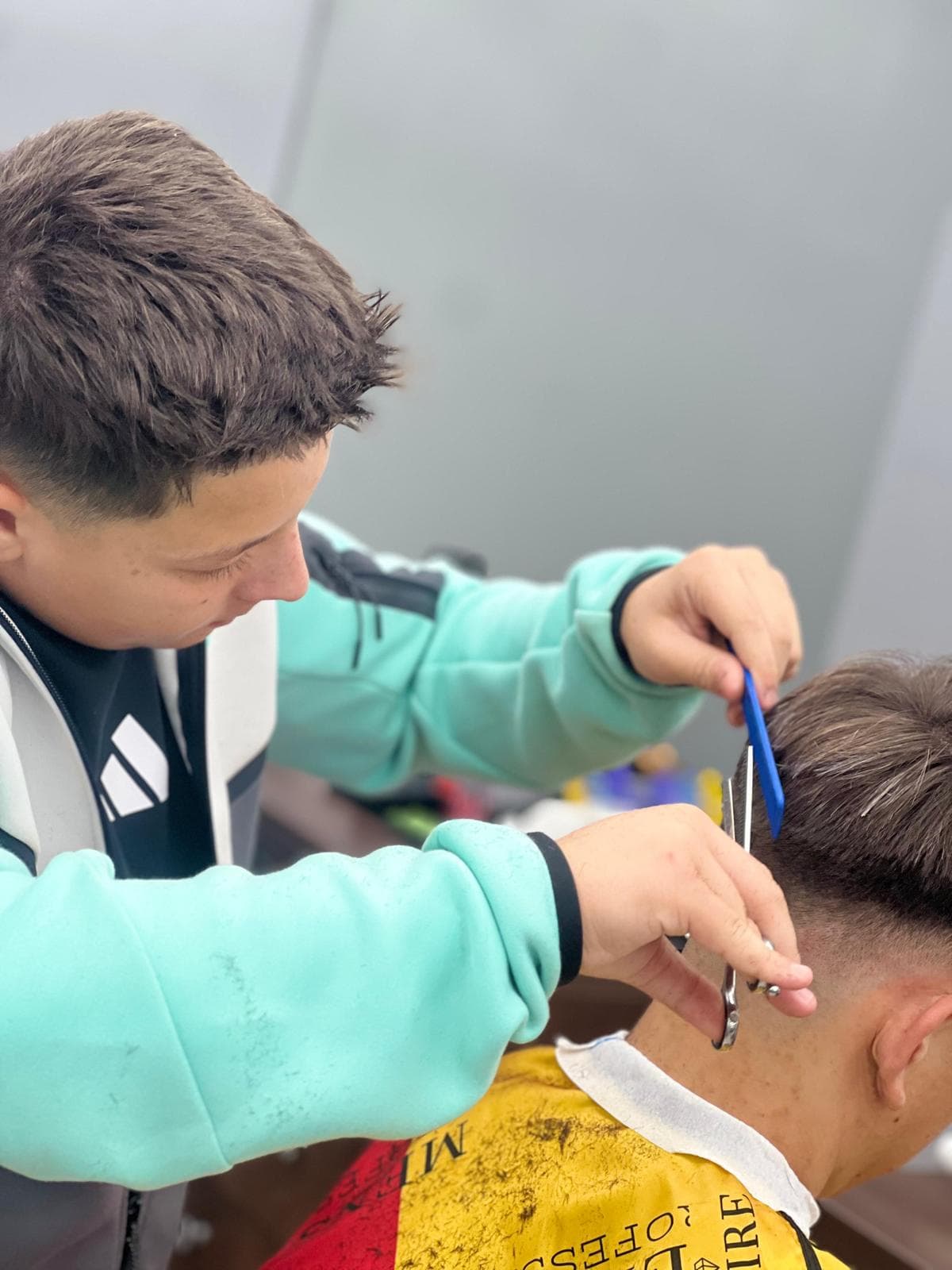 Cursant sub 18 ani la cursul de frizerie PointCut Pitești, la lucru pe model real sub supravegherea instructorului — imaginea 8